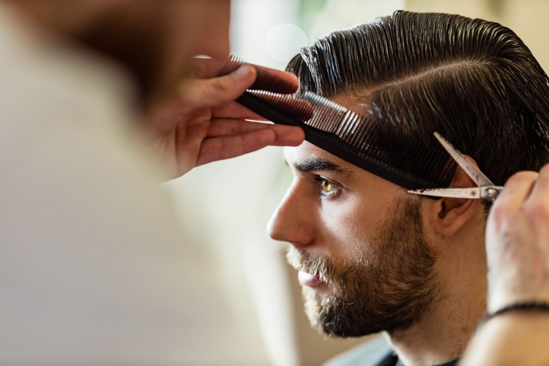 A gents cut being detailed with comb and scissors